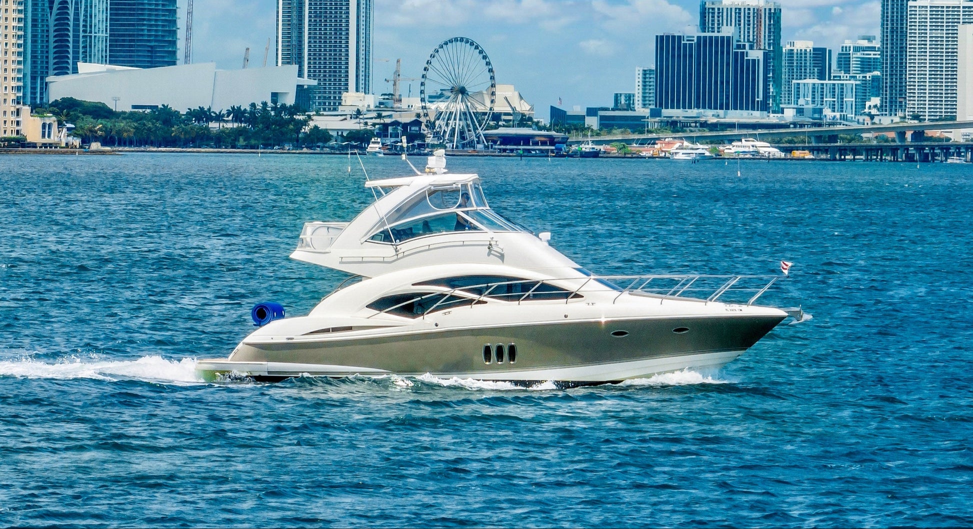 Yacht on water with city skyline in the background
